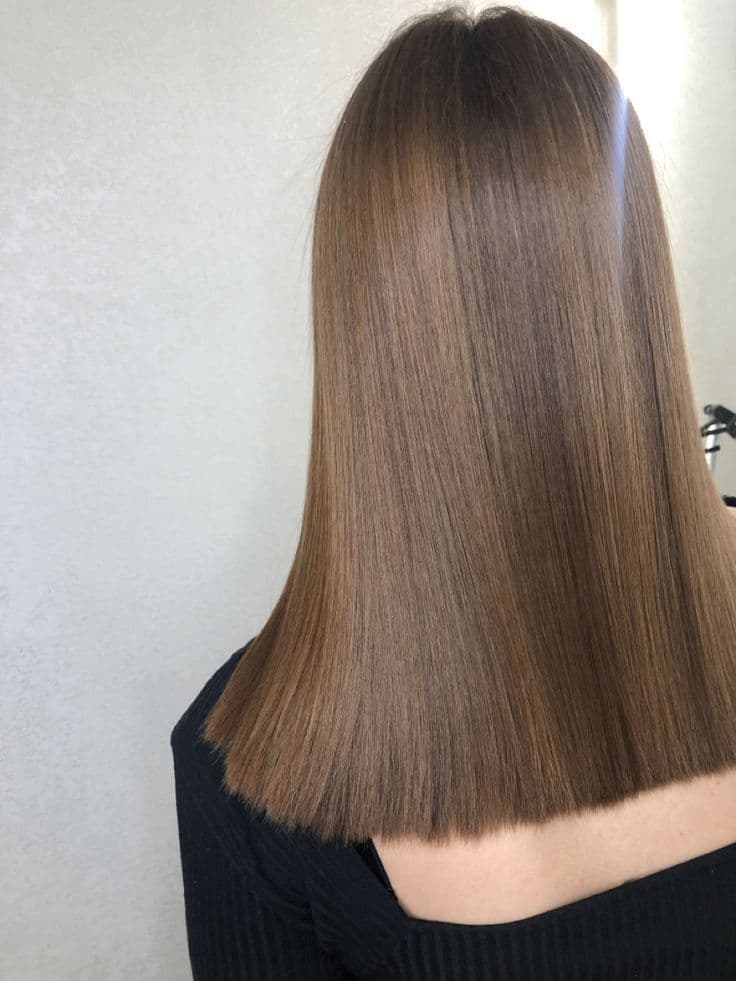 Cabello largo, liso y castaño claro con un corte recto impecable visto desde atrás.
